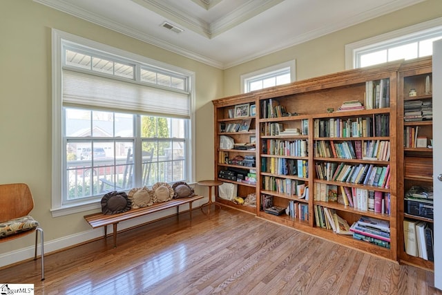 living area featuring ornamental molding, light hardwood / wood-style floors, and a wealth of natural light