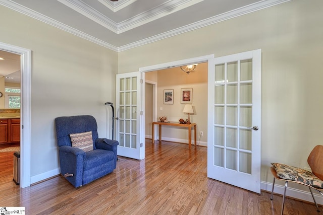 living area featuring french doors, crown molding, and light hardwood / wood-style floors