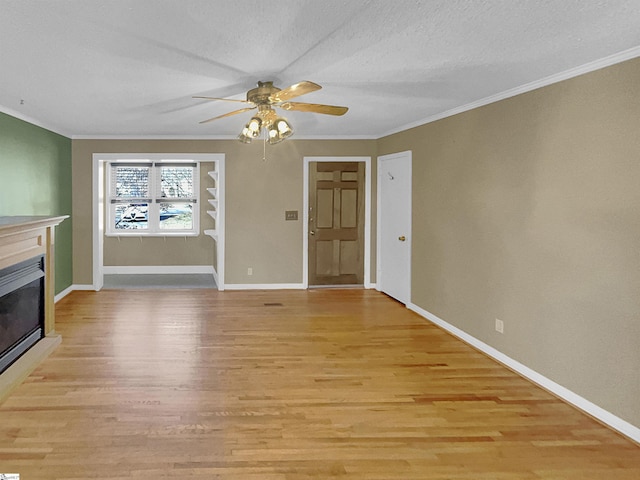 unfurnished living room featuring ornamental molding, a textured ceiling, and light wood-type flooring