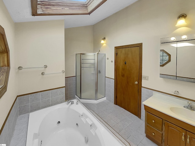 bathroom featuring vanity, a skylight, independent shower and bath, and tile walls