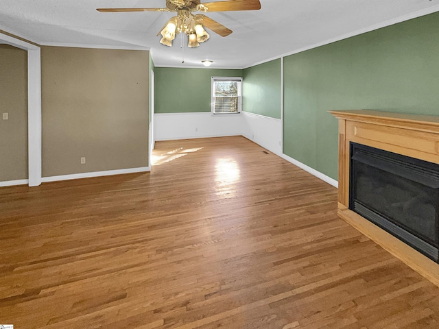 unfurnished living room with crown molding, ceiling fan, and hardwood / wood-style floors