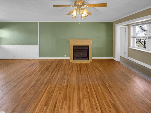 unfurnished living room featuring ornamental molding, hardwood / wood-style floors, and ceiling fan