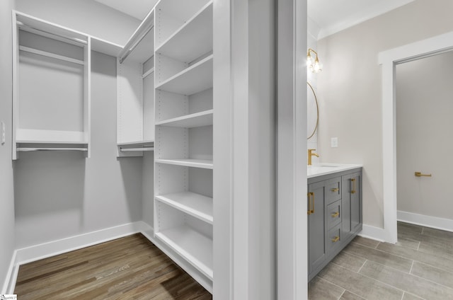 spacious closet featuring sink and light wood-type flooring