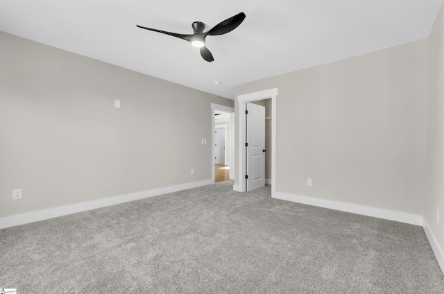 unfurnished bedroom featuring ceiling fan, a walk in closet, and carpet flooring