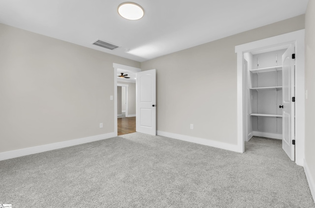 unfurnished bedroom with a walk in closet, carpet flooring, and a closet