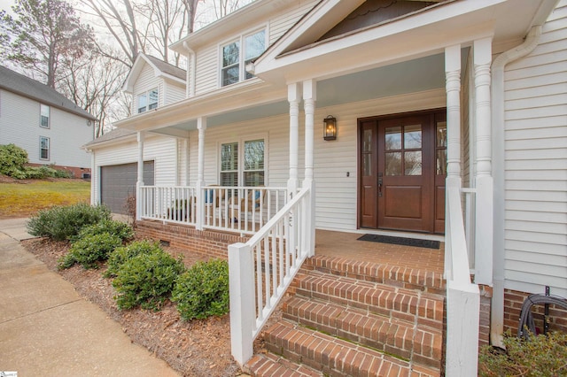 view of exterior entry featuring a garage and a porch