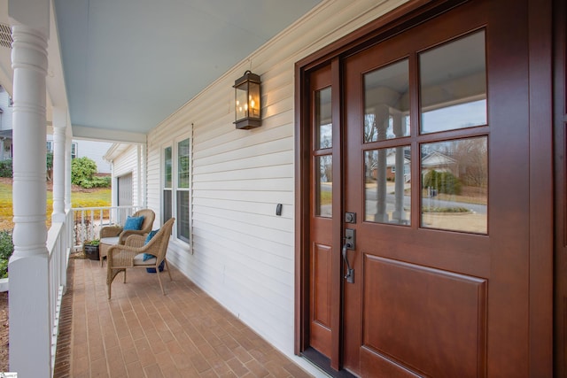 view of exterior entry featuring covered porch