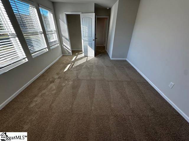 unfurnished bedroom featuring dark carpet