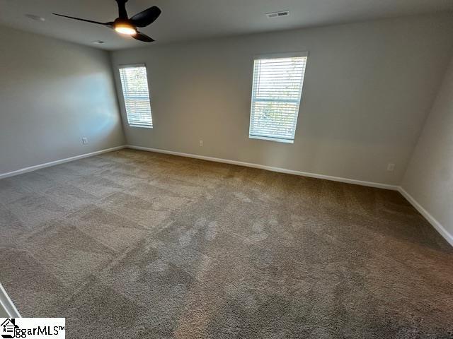 spare room featuring ceiling fan and carpet