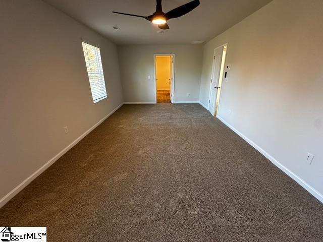 carpeted spare room with ceiling fan