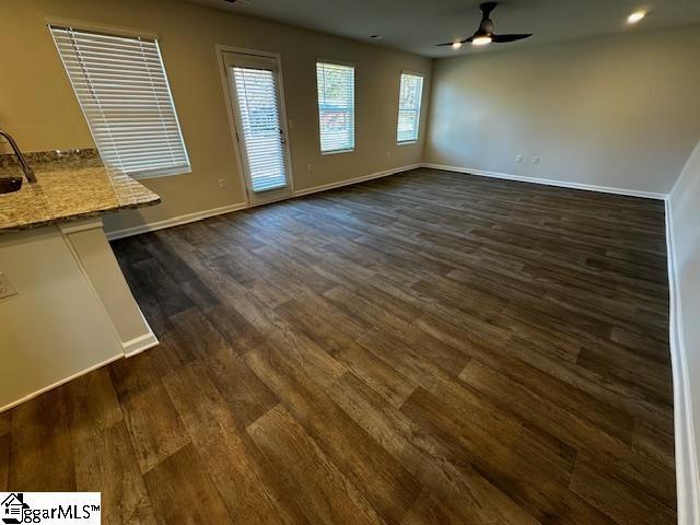 unfurnished dining area featuring dark wood-type flooring and ceiling fan