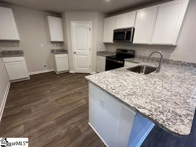 kitchen featuring white cabinetry, black electric range oven, sink, and kitchen peninsula