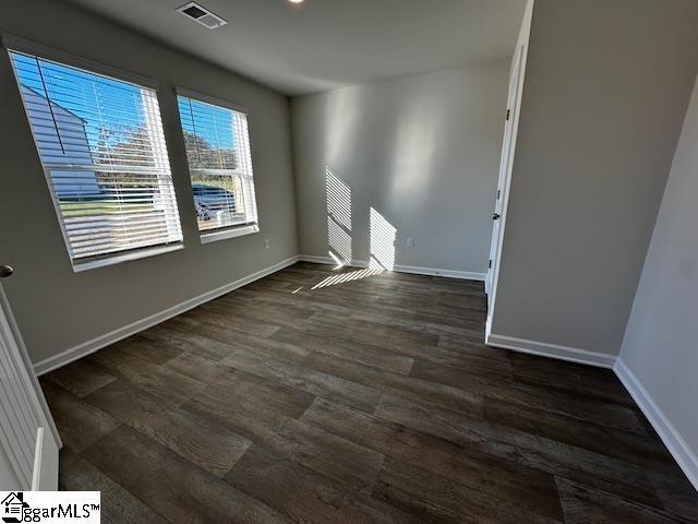 spare room with dark wood-type flooring