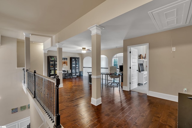 interior space with dark hardwood / wood-style flooring and decorative columns