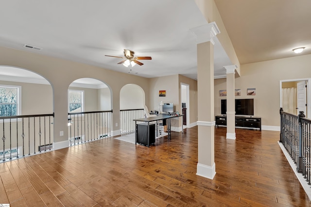 living room with decorative columns, dark hardwood / wood-style floors, and ceiling fan