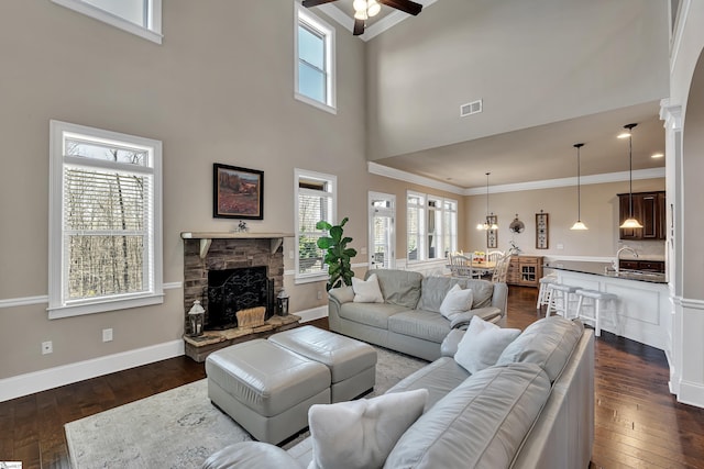 living room with ornamental molding, dark hardwood / wood-style floors, and a wealth of natural light