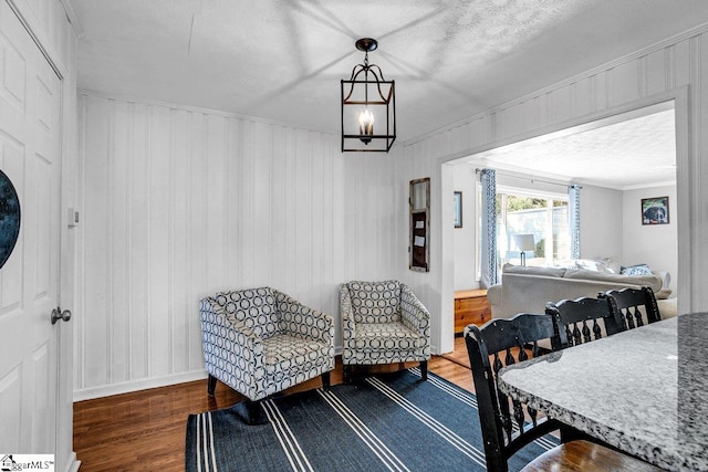 dining room with crown molding, a chandelier, hardwood / wood-style floors, and a textured ceiling