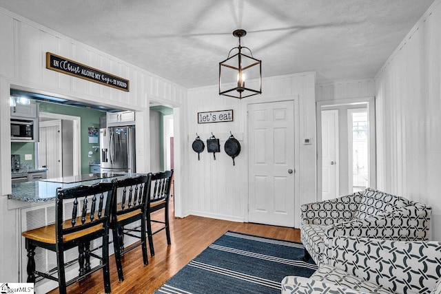 entrance foyer with wood-type flooring, a textured ceiling, and crown molding