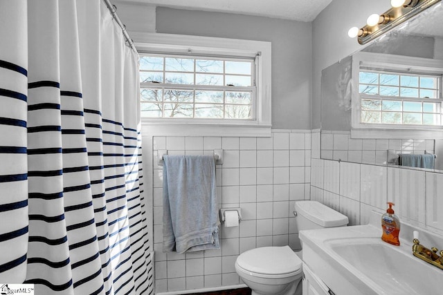 bathroom featuring tile walls, vanity, plenty of natural light, and toilet