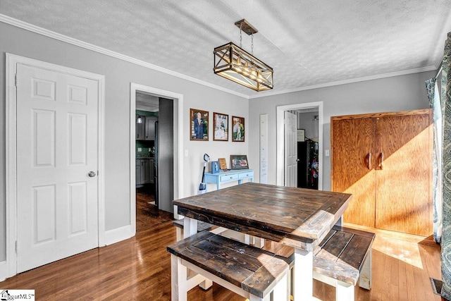 dining area featuring ornamental molding, dark hardwood / wood-style flooring, and a textured ceiling