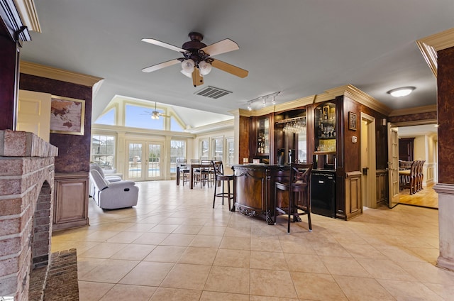 kitchen featuring crown molding, a breakfast bar area, a fireplace, and french doors