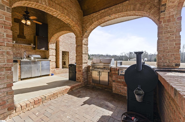 view of patio featuring grilling area, ceiling fan, and an outdoor kitchen