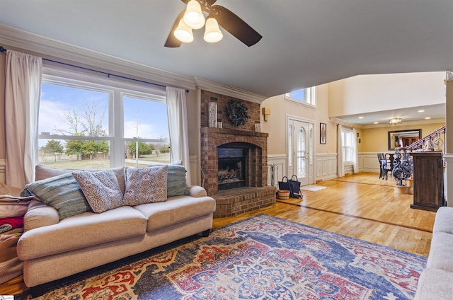 living room featuring hardwood / wood-style flooring, ceiling fan, and a fireplace