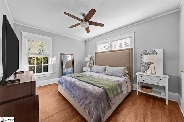 bedroom featuring hardwood / wood-style flooring, ornamental molding, and multiple windows