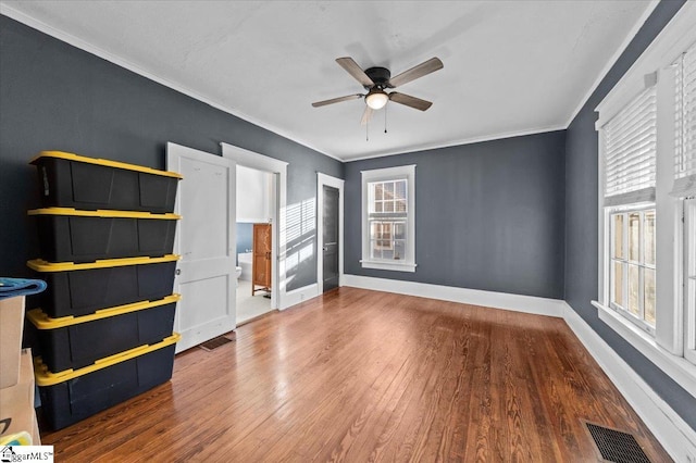 unfurnished bedroom featuring multiple windows, hardwood / wood-style floors, crown molding, and ceiling fan