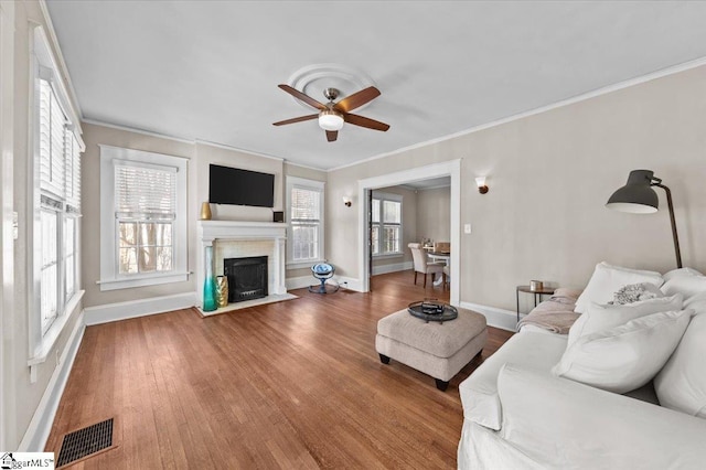 unfurnished living room with hardwood / wood-style floors, crown molding, a healthy amount of sunlight, and ceiling fan