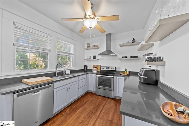 kitchen with sink, gray cabinetry, dark hardwood / wood-style floors, stainless steel appliances, and wall chimney range hood