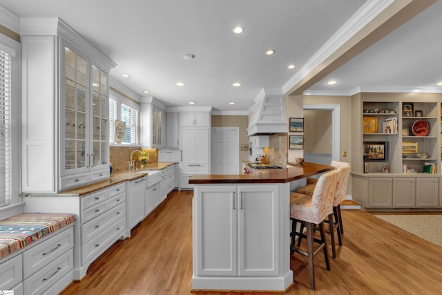 12 Cothran St, Greenville, SC 29605 - kitchen featuring premium range hood, white cabinetry, a center island, light hardwood / wood-style flooring, and a kitchen breakfast bar