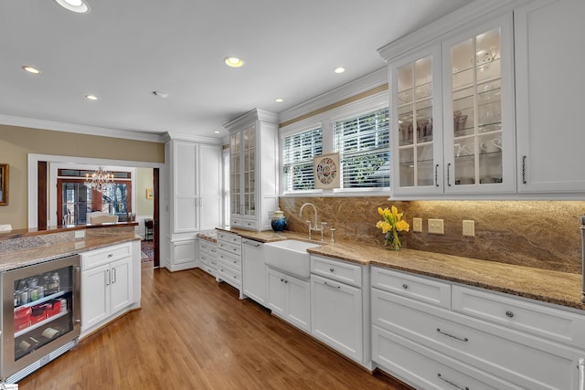 12 Cothran St, Greenville, SC 29605 - kitchen with sink, white cabinets, beverage cooler, ornamental molding, and light stone counters