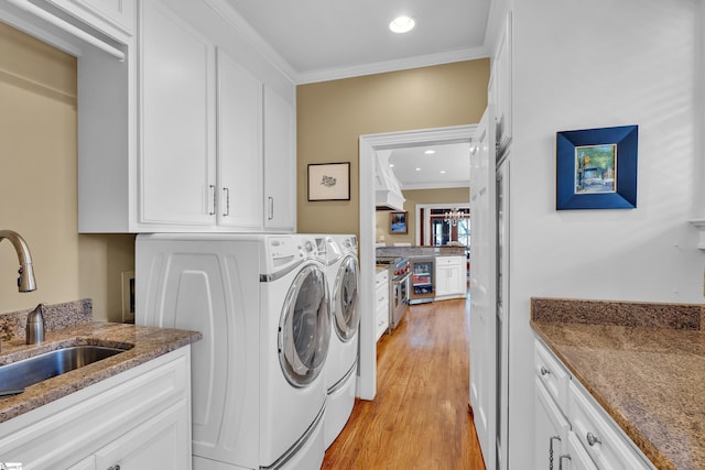 12 Cothran St, Greenville, SC 29605 - clothes washing area featuring sink, cabinets, separate washer and dryer, light wood-type flooring, and ornamental molding