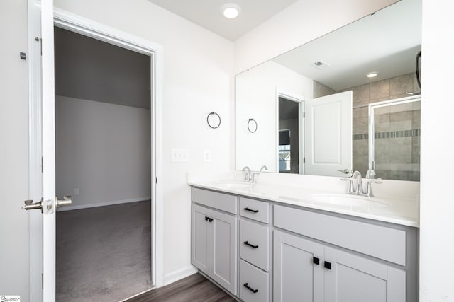 bathroom with hardwood / wood-style flooring, vanity, and walk in shower