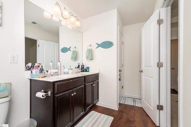 bathroom featuring wood-type flooring, toilet, and vanity