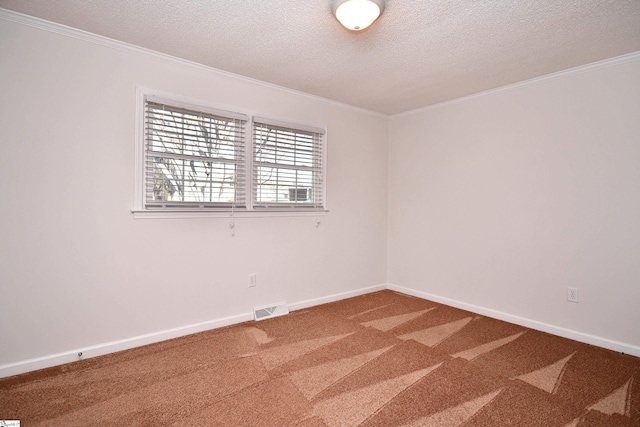 carpeted spare room with a textured ceiling, ornamental molding, and visible vents