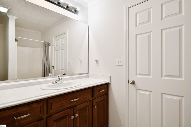 bathroom with vanity, ornamental molding, a textured ceiling, and a shower with shower curtain