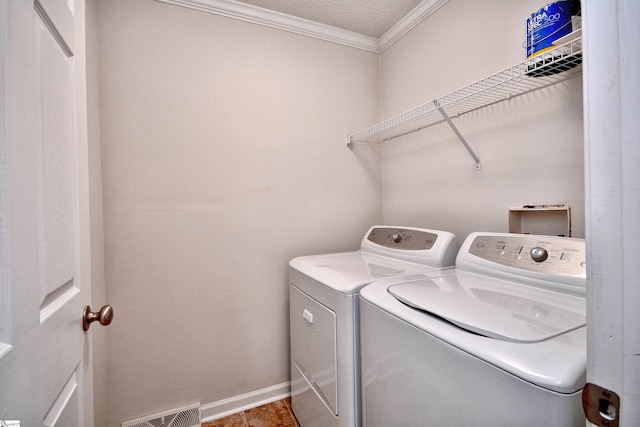 clothes washing area with washer and clothes dryer, visible vents, ornamental molding, laundry area, and baseboards