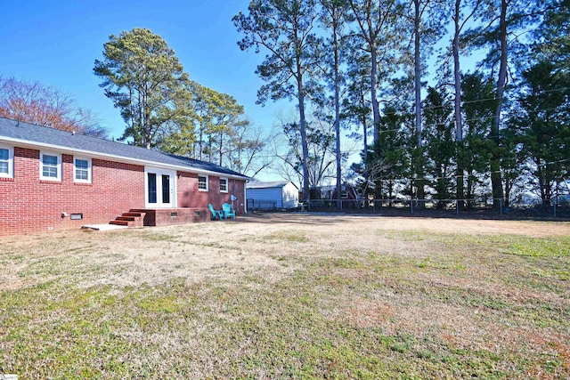 view of yard featuring entry steps and fence