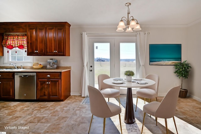 dining area featuring ornamental molding, baseboards, and an inviting chandelier