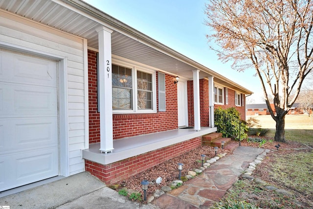 doorway to property with a garage and a porch