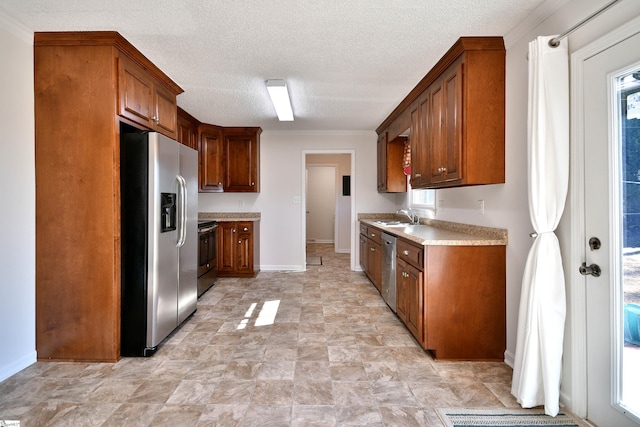 kitchen featuring appliances with stainless steel finishes, sink, and a textured ceiling