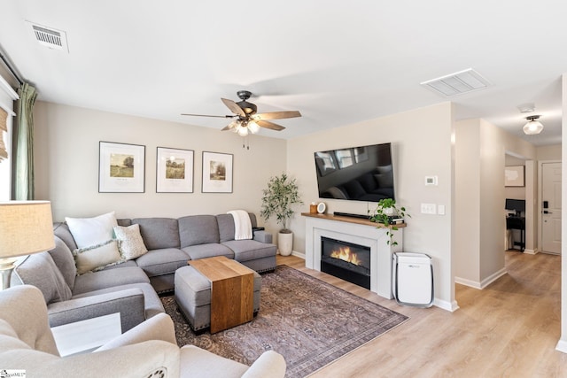 living room featuring ceiling fan and light wood-type flooring