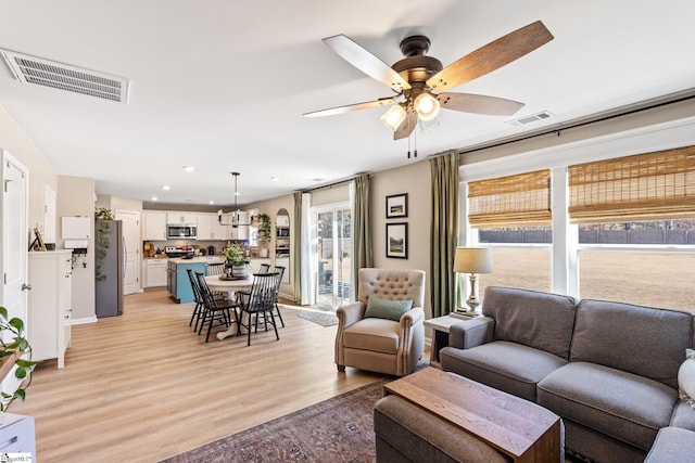 living room with ceiling fan and light wood-type flooring