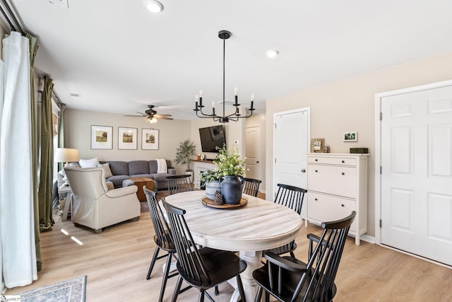 dining area featuring ceiling fan with notable chandelier and light hardwood / wood-style flooring