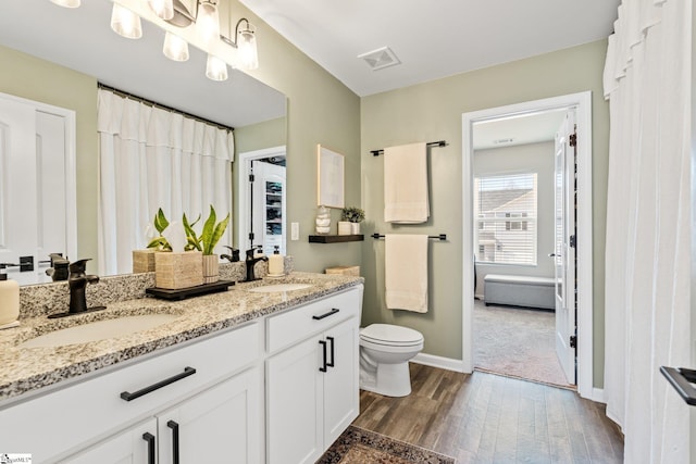 bathroom featuring vanity, hardwood / wood-style floors, and toilet