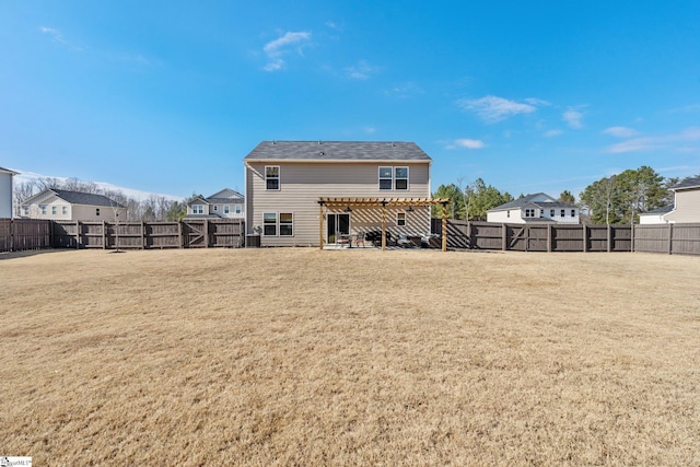 back of property with a pergola and a lawn