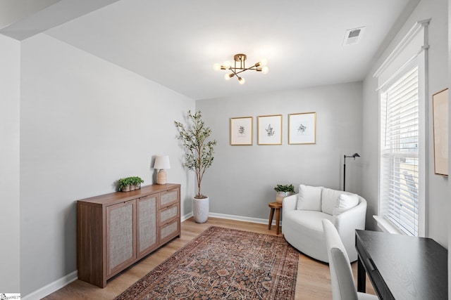 sitting room featuring an inviting chandelier and light hardwood / wood-style flooring