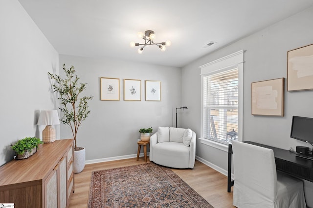 home office featuring light hardwood / wood-style floors and a notable chandelier